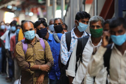 Passengers wearing protective face masks stand in a queue on a platform to get tested for the coronavirus disease, at a railway station, in New Delh. (Reuters)
