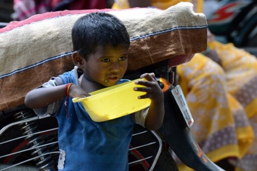 A file photo shows a child eating from a bowl on a street in a slum in Hyderabad. (AFP)