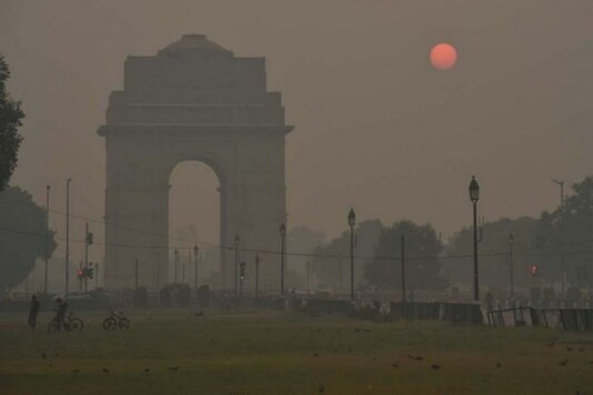 View of India Gate covered in haze in the backdrop of rising sun, in New Delhi. (Image: PTI)