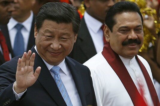 In this file photo, Chinese President Xi Jinping (L) waves next to Sri Lanka's Prime Minister Mahinda Rajapaksa during an official welcoming ceremony at Bandaranaike International Airport in Katunayake. (Reuters/Dinuka Liyanawatte)
