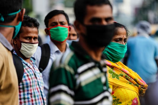 Commuters wearing face masks as a precautionary measure against the coronavirus wait for a bus in Kolkata, on October 10, 2020. (AP Photo/Bikas Das) Commuters wearing face masks as a precautionary measure against the coronavirus wait for a bus in Kolkata, on October 10, 2020. (AP Photo/Bikas Das)