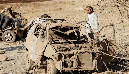 FILE PHOTO: An Afghan man inspects the wreckage of a car at the site of a truck bomb blast in Ghani Khel district of Nangarhar province, Afghanistan, October 3, 2020.REUTERS/Parwiz/File Photo
