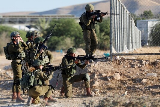 File photo: Israeli troops point their weapons at Palestinian demonstrators during a protest against Israel's plan to annex parts of the occupied West Bank, in Jordan Valley June 24, 2020. REUTERS/Mohamad Torokman