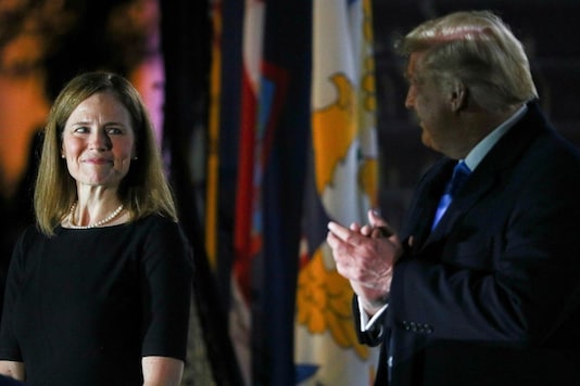 Judge Amy Coney Barrett looks over at U.S. President Donald Trump as he stands behind a teleprompter before Barrett is sworn in to serve as an associate justice of the U.S. Supreme Court on the South Lawn of the White House in Washington, U.S., October 26, 2020. REUTERS/Tom Brenner
Judge Amy Coney Barrett looks over at U.S. President Donald Trump as he stands behind a teleprompter before Barrett is sworn in to serve as an associate justice of the U.S. Supreme Court on the South Lawn of the White House in Washington, U.S., October 26, 2020. REUTERS/Tom Brenner