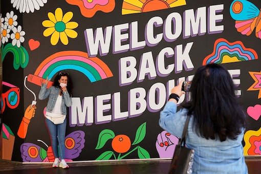 People take photos in front of a 'Welcome Back' sign in Melbourne after coronavirus disease (COVID-19) restrictions were eased for the state of Victoria, Australia, October 28, 2020.  REUTERS/Sandra Sanders