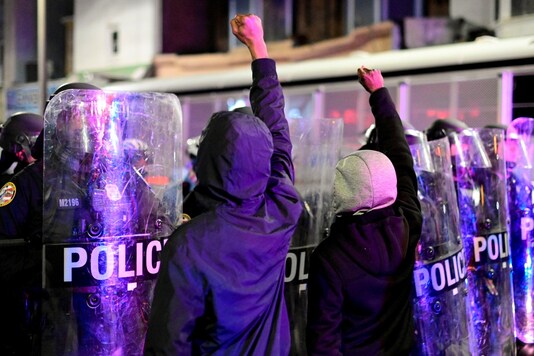 Demonstrators raise their fists in front of police officers during a rally after the death of Walter Wallace Jr., a Black man who was shot by police in Philadelphia, Pennsylvania, U.S., October 27, 2020. REUTERS/Bastiaan Slabbers