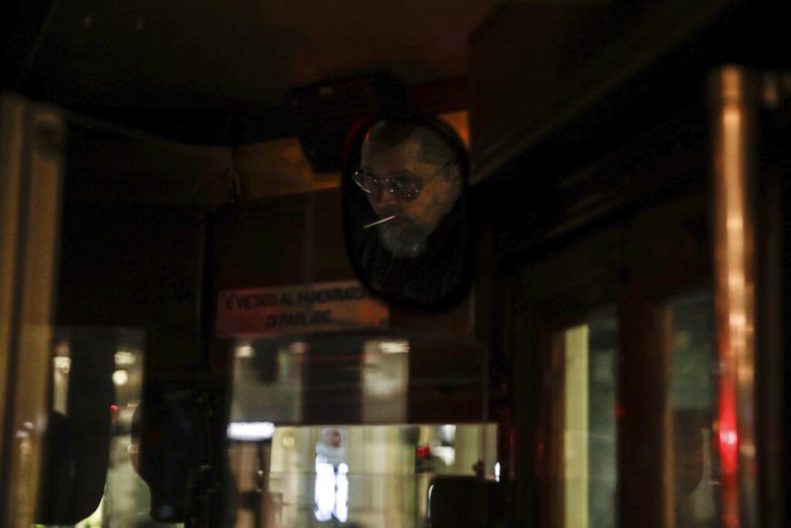  A streetcar driver is reflected in a mirror as he drives around Milan, Italy. (Image: AP)