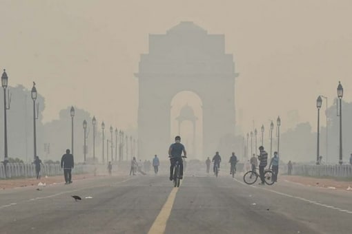 A cyclist rides near India Gate in New Delhi. (Image: PTI)