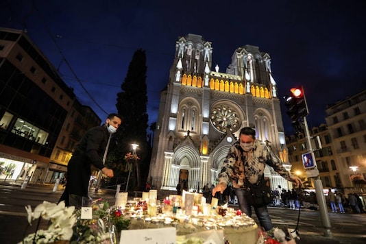 People light candles outside the Notre-Dame de l'Assomption Basilica in Nice on October 30, 2020, a day after a knife attacker killed three people. (Photo by Valery HACHE / AFP) People light candles outside the Notre-Dame de l'Assomption Basilica in Nice on October 30, 2020, a day after a knife attacker killed three people. (Photo by Valery HACHE / AFP)