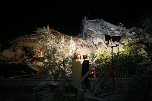 Local residents watch as members of rescue services search in the debris of a collapsed building for survivors in Izmir, Turkey, early Saturday, Oct. 31, 2020. A strong earthquake struck Friday in the Aegean Sea between the Turkish coast and the Greek island of Samos, killing several people and injuring hundreds amid collapsed buildings and flooding. (AP Photo/Emrah Gurel)