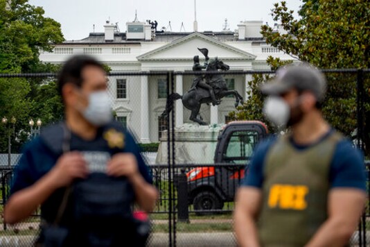 FILE - In this June 2, 2020, file photo the White House is visible behind a large security fence as uniformed Secret Service and FBI agents stand on the street in front of Lafayette Park in the morning hours in Washington. Federal and state law enforcement officials have begun expanded preparations for the possibility of widespread unrest at the polls on Election Day, a response to extraordinarily high tensions among voters and anxieties about safety stoked in part by President Donald Trump. (AP Photo/Andrew Harnik, File) FILE - In this June 2, 2020, file photo the White House is visible behind a large security fence as uniformed Secret Service and FBI agents stand on the street in front of Lafayette Park in the morning hours in Washington. Federal and state law enforcement officials have begun expanded preparations for the possibility of widespread unrest at the polls on Election Day, a response to extraordinarily high tensions among voters and anxieties about safety stoked in part by President Donald Trump. (AP Photo/Andrew Harnik, File)