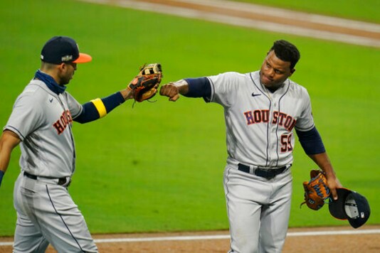 Houston Astros starting pitcher Framber Valdez, right, pumps fists with Carlos Correa following the fifth inning in Game 1 of a baseball American League Championship Series, Sunday, Oct. 11, 2020, in San Diego. (AP Photo/Gregory Bull)