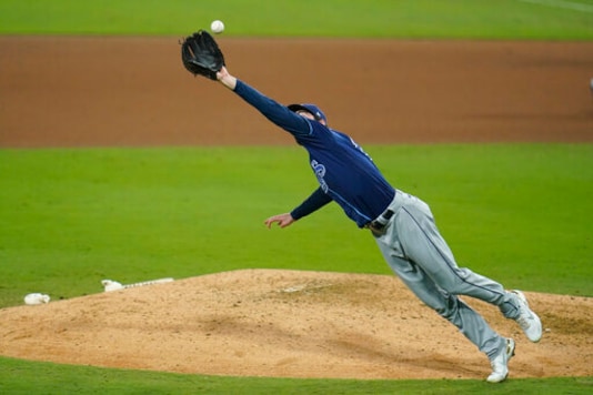 Tampa Bay Rays' pitcher John Curtiss reaches out to catch an infield hit by Houston Astros' Yuli Gurriel during the seventh inning in Game 3 of a baseball American League Championship Series, Tuesday, Oct. 13, 2020, in San Diego. (AP Photo/Gregory Bull) Tampa Bay Rays' pitcher John Curtiss reaches out to catch an infield hit by Houston Astros' Yuli Gurriel during the seventh inning in Game 3 of a baseball American League Championship Series, Tuesday, Oct. 13, 2020, in San Diego. (AP Photo/Gregory Bull)