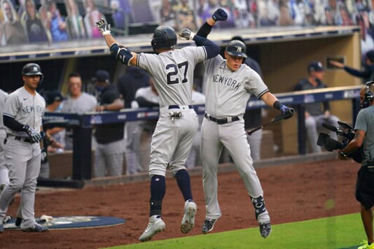 New York Yankees' Giancarlo Stanton (27) celebrates with Gio Urshela, right, after Stanton hit a solo home run against the Tampa Bay Rays during the second inning in Game 2 of a baseball American League Division Series Tuesday, Oct. 6, 2020, in San Diego. (AP Photo/Gregory Bull) New York Yankees' Giancarlo Stanton (27) celebrates with Gio Urshela, right, after Stanton hit a solo home run against the Tampa Bay Rays during the second inning in Game 2 of a baseball American League Division Series Tuesday, Oct. 6, 2020, in San Diego. (AP Photo/Gregory Bull)