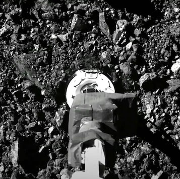 In this image taken from video released by NASA, the Osiris-Rex spacecraft touches the surface of asteroid Bennu on Tuesday, Oct. 20, 2020. (NASA via AP)