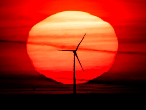The sun rises behind a wind turbine in Frankfurt, Germany, early Tuesday, Sept. 15, 2020. (AP Photo/Michael Probst)