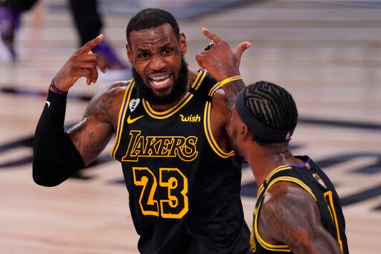 Los Angeles Lakers forward LeBron James talks with guard Kentavious Caldwell-Pope during the first half in Game 5 of basketball's NBA Finals against the Miami Heat Friday, Oct. 9, 2020, in Lake Buena Vista, Fla. (AP Photo/Mark J. Terrill)