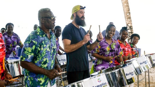 In this 2018 photo provided by CBS, professional volleyball player Maddison McKibbin, center, participates at an event in Trinidad and Tobago. Maddison McKibbin and his brother Riley McKibbin will be competing on The Amazing Race travel challenge reality show that premiers for its 32nd season on Oct. 14, 2020. (Timothy Kuratek/CBS via AP) In this 2018 photo provided by CBS, professional volleyball player Maddison McKibbin, center, participates at an event in Trinidad and Tobago. Maddison McKibbin and his brother Riley McKibbin will be competing on The Amazing Race travel challenge reality show that premiers for its 32nd season on Oct. 14, 2020. (Timothy Kuratek/CBS via AP)