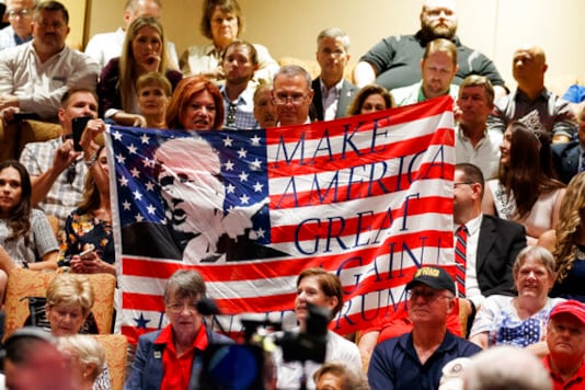 FILE - In this Thursday, Oct. 3, 2019 file photo, supporters of President Donald Trump hold a flag before he arrives to deliver remarks on Medicare at the Sharon L. Morse Performing Arts Center in The Villages, Fla. (AP Photo/Evan Vucci) FILE - In this Thursday, Oct. 3, 2019 file photo, supporters of President Donald Trump hold a flag before he arrives to deliver remarks on Medicare at the Sharon L. Morse Performing Arts Center in The Villages, Fla. (AP Photo/Evan Vucci)
