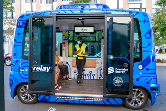 Deployment Manager Jason Peres, center, explains how Relay, an electric autonomous vehicle, works to new riders in Fairfax, Va., Thursday, Oct. 22, 2020. The future of transportation arrived in northern Virginia, looking like a big blue toaster on wheels that can seat six and drive itself through the regions notorious traffic. State and local officials debuted the Relay system Thursday, an all-electric, autonomous vehicle that will provide free shuttle rides back and forth from the Dunn Loring Metrorail stop to the bustling Mosaic District in Fairfax County, Va. (AP Photo/Jacquelyn Martin) Deployment Manager Jason Peres, center, explains how Relay, an electric autonomous vehicle, works to new riders in Fairfax, Va., Thursday, Oct. 22, 2020. The future of transportation arrived in northern Virginia, looking like a big blue toaster on wheels that can seat six and drive itself through the regions notorious traffic. State and local officials debuted the Relay system Thursday, an all-electric, autonomous vehicle that will provide free shuttle rides back and forth from the Dunn Loring Metrorail stop to the bustling Mosaic District in Fairfax County, Va. (AP Photo/Jacquelyn Martin)