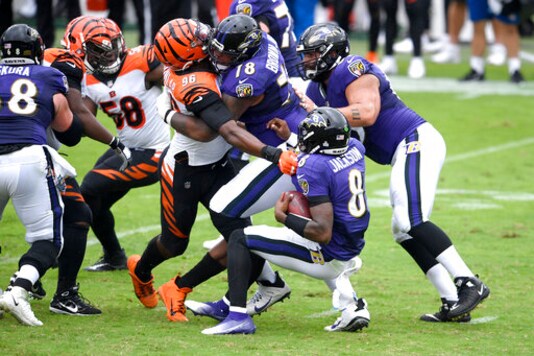 Cincinnati Bengals defensive end Carlos Dunlap (96) is able to sack Baltimore Ravens quarterback Lamar Jackson (8) in spite of being blocked by Ravens offensive tackle Orlando Brown (78) during the first half of an NFL football game, Sunday, Oct. 11, 2020, in Baltimore. (AP Photo/Nick Wass)