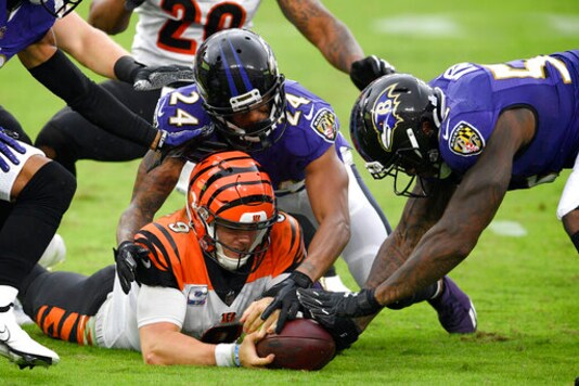 Cincinnati Bengals quarterback Joe Burrow, bottom left, tries to retrieve his fumble as Baltimore Ravens cornerback Marcus Peters (24) and defensive end Jihad Ward (53) challenge him for the recovery during the second half of an NFL football game, Sunday, Oct. 11, 2020, in Baltimore. The ball bounced out of bounds and the Bengals retained possession. (AP Photo/Nick Wass) Cincinnati Bengals quarterback Joe Burrow, bottom left, tries to retrieve his fumble as Baltimore Ravens cornerback Marcus Peters (24) and defensive end Jihad Ward (53) challenge him for the recovery during the second half of an NFL football game, Sunday, Oct. 11, 2020, in Baltimore. The ball bounced out of bounds and the Bengals retained possession. (AP Photo/Nick Wass)