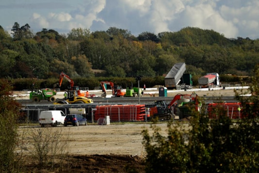 Construction takes place on a post-Brexit customs clearance border post facility on land that was previously a field between the villages of Mersham and Sevington in the county of Kent, south east England, Tuesday, Oct. 6, 2020. In the corner of Britain known as the Garden of England, Brexit is literally taking concrete form. Diggers, dump trucks and cement mixers are transforming a field in the village of Sevington into a customs clearance depot with room for up to 2,000 trucks. It's part of Britain's new border with the European Union, and no one asked the locals for their permission. (AP Photo/Matt Dunham) Construction takes place on a post-Brexit customs clearance border post facility on land that was previously a field between the villages of Mersham and Sevington in the county of Kent, south east England, Tuesday, Oct. 6, 2020. In the corner of Britain known as the Garden of England, Brexit is literally taking concrete form. Diggers, dump trucks and cement mixers are transforming a field in the village of Sevington into a customs clearance depot with room for up to 2,000 trucks. It's part of Britain's new border with the European Union, and no one asked the locals for their permission. (AP Photo/Matt Dunham)