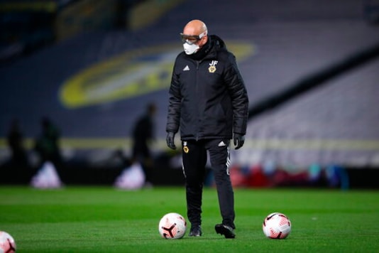 A Leeds United's assistant coach, name not available, wearing protective goggles and a mask, to help prevent the spread of coronavirus, helps players to warm up prior to the English Premier League soccer match between Leeds United and Wolverhampton Wanderers at Elland Road ground in Leeds, England, Monday, Oct. 19, 2020. (Martin Rickett/Pool via AP) A Leeds United's assistant coach, name not available, wearing protective goggles and a mask, to help prevent the spread of coronavirus, helps players to warm up prior to the English Premier League soccer match between Leeds United and Wolverhampton Wanderers at Elland Road ground in Leeds, England, Monday, Oct. 19, 2020. (Martin Rickett/Pool via AP)