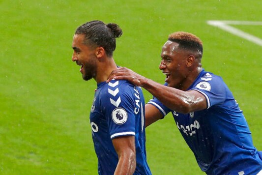 Everton's Dominic Calvert-Lewin, left, celebrates after scoring his side's first goal during the English Premier League soccer match between Everton and Brighton at the Goodison Park stadium in Liverpool, England, Saturday, Oct. 3, 2020. (Peter Byrne/Pool via AP)