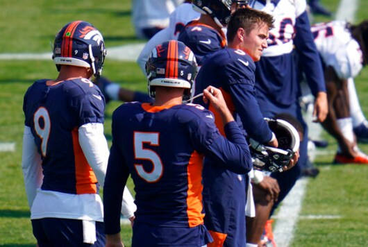 Injured Denver Broncos quarterback Drew Lock (3), right,, puts on his helmet to take part in drills during an NFL football practice at the team's training headquarters Wednesday, Oct. 7, 2020, in Englewood, Colo. (AP Photo/David Zalubowski)