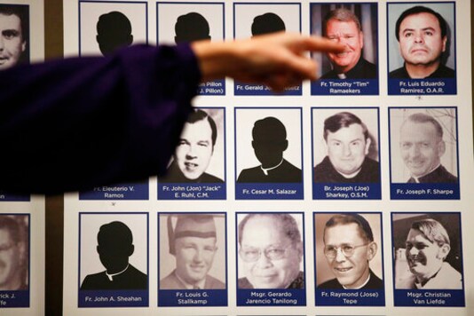 FILE - In this Thursday, Dec. 6, 2018 file photo, a sexual abuse victim points to the photos of Catholic priests accused of sexual misconduct by victims during a news conference in Orange, Calif. The child-protection policies adopted by Roman Catholic leaders to curb clergy sex abuse in the U.S. are inconsistent and often worryingly incomplete, according to the Philadelphia-based CHILD USA think tanks 2018-2020 investigation of policies in all 32 archdioceses. (AP Photo/Jae C. Hong) FILE - In this Thursday, Dec. 6, 2018 file photo, a sexual abuse victim points to the photos of Catholic priests accused of sexual misconduct by victims during a news conference in Orange, Calif. The child-protection policies adopted by Roman Catholic leaders to curb clergy sex abuse in the U.S. are inconsistent and often worryingly incomplete, according to the Philadelphia-based CHILD USA think tanks 2018-2020 investigation of policies in all 32 archdioceses. (AP Photo/Jae C. Hong)