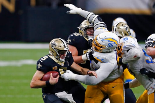 New Orleans Saints quarterback Drew Brees (9) tries to avoid the sack by Los Angeles Chargers defensive tackle Linval Joseph (95) in the second half of an NFL football game in New Orleans, Monday, Oct. 12, 2020. (AP Photo/Brett Duke) New Orleans Saints quarterback Drew Brees (9) tries to avoid the sack by Los Angeles Chargers defensive tackle Linval Joseph (95) in the second half of an NFL football game in New Orleans, Monday, Oct. 12, 2020. (AP Photo/Brett Duke)