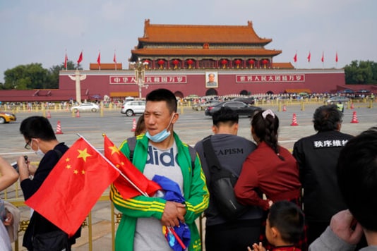 A tourists visiting Tiananmen Square holds Chinese national flags in Beijing on Thursday, Oct. 1, 2020. Some 637 million Chinese tourists took domestic trips during the 8-day long Golden Week holidays, spending billions as China looked to boost consumer-led spending to stimulate the economy. (AP Photo/Ng Han Guan) A tourists visiting Tiananmen Square holds Chinese national flags in Beijing on Thursday, Oct. 1, 2020. Some 637 million Chinese tourists took domestic trips during the 8-day long Golden Week holidays, spending billions as China looked to boost consumer-led spending to stimulate the economy. (AP Photo/Ng Han Guan)