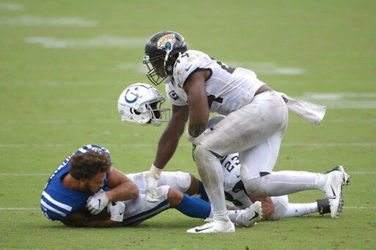 Indianapolis Colts wide receiver Michael Pittman loses his helmet after he was tackled by Jacksonville Jaguars middle linebacker Myles Jack and cornerback C.J. Henderson, back, during the second half of an NFL football game, Sunday, Sept. 13, 2020, in Jacksonville, Fla. (AP Photo/Phelan M. Ebenhack)