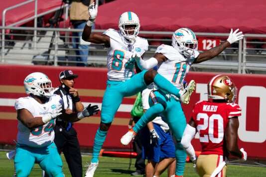 Miami Dolphins wide receiver DeVante Parker (11) celebrates after scoring against the San Francisco 49ers with wide receiver Isaiah Ford (84) and defensive tackle Christian Wilkins (94) during the first half of an NFL football game in Santa Clara, Calif., Sunday, Oct. 11, 2020. Also pictured at right is 49ers free safety Jimmie Ward (20). (AP Photo/Tony Avelar)
