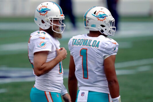 Miami Dolphins quarterbacks Ryan Fitzpatrick (14) and Tua Tagovailoa (1) warm up before an NFL football game against the New England Patriots, Sunday, Sept. 13, 2020, in Foxborough, Mass. (AP Photo/Charles Krupa) Miami Dolphins quarterbacks Ryan Fitzpatrick (14) and Tua Tagovailoa (1) warm up before an NFL football game against the New England Patriots, Sunday, Sept. 13, 2020, in Foxborough, Mass. (AP Photo/Charles Krupa)