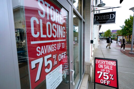 FILE - In this Sept. 2, 2020 file photo, pedestrians walk past a business storefront with store closing and sale signs in Dedham, Mass. The U.S. economy plunged at a record rate in the spring but is poised to break a record for an increase in the just-ending July-September quarter. The Commerce Department reported Wednesday, Sept. 30, that the gross domestic product, the economys total output of goods and services, fell at a rate of 31.4% in the April-June quarter, only slightly changed from the 31.7% drop estimated one month ago. (AP Photo/Steven Senne) FILE - In this Sept. 2, 2020 file photo, pedestrians walk past a business storefront with store closing and sale signs in Dedham, Mass. The U.S. economy plunged at a record rate in the spring but is poised to break a record for an increase in the just-ending July-September quarter. The Commerce Department reported Wednesday, Sept. 30, that the gross domestic product, the economys total output of goods and services, fell at a rate of 31.4% in the April-June quarter, only slightly changed from the 31.7% drop estimated one month ago. (AP Photo/Steven Senne)