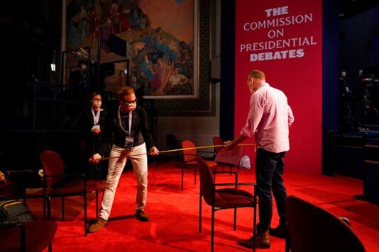 Staff members with the Commission on Presidential Debates measure out the distance between spectators' chairs as preparations take place for the vice presidential debate in Kingsbury Hall at the University of Utah, Tuesday, Oct. 6, 2020, in Salt Lake City. The vice presidential debate is scheduled to take place Wednesday, Oct. 7. (AP Photo/Patrick Semansky) Staff members with the Commission on Presidential Debates measure out the distance between spectators' chairs as preparations take place for the vice presidential debate in Kingsbury Hall at the University of Utah, Tuesday, Oct. 6, 2020, in Salt Lake City. The vice presidential debate is scheduled to take place Wednesday, Oct. 7. (AP Photo/Patrick Semansky)