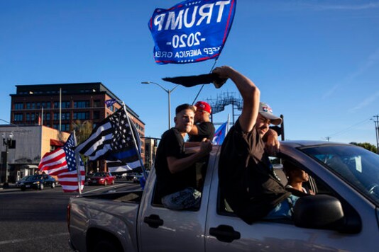 FILE-This Saturday, Aug. 29, 2020 file photo shows supporters of President Donald Trump attending a rally and car parade in Clackamas, Ore. Grassroots supporters for President Donald Trump have organized hundreds of boat, car and tractor parades across the nation to generate enthusiasm for his re-election campaign. Campaign strategists and analysts say the parades are a reflection of the president's populist appeal, but they have varying thoughts on whether they will impact the outcome. (AP Photo/Paula Bronstein, File )