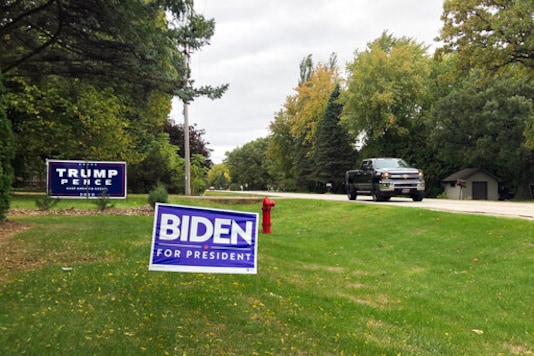 Signs for Democratic presidential candidate former Vice President Joe Biden and President Donald Trump mark neighboring property in a middle-class neighborhood of Oshkosh, the hub of swing-voting Winnebago County Wis. Trumps standing with white, working class voters has proven resilient through federal investigations, impeachment and countless episodes of chaotic governing. But if those issues were too distant centered on complicated foreign entanglements reports about his tax avoidance might have had the potential to hit closer to home during a time of economic upheaval. (AP Photo/Thomas Beaumont) Signs for Democratic presidential candidate former Vice President Joe Biden and President Donald Trump mark neighboring property in a middle-class neighborhood of Oshkosh, the hub of swing-voting Winnebago County Wis. Trumps standing with white, working class voters has proven resilient through federal investigations, impeachment and countless episodes of chaotic governing. But if those issues were too distant centered on complicated foreign entanglements reports about his tax avoidance might have had the potential to hit closer to home during a time of economic upheaval. (AP Photo/Thomas Beaumont)