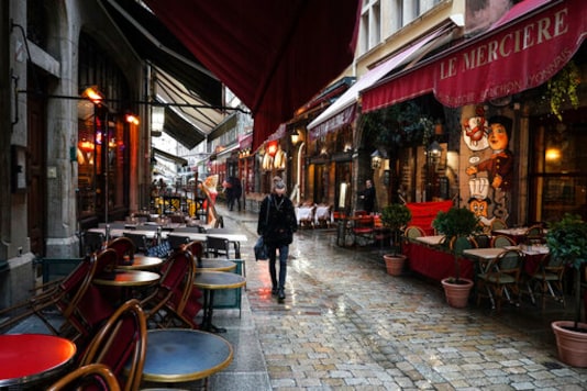 FILE - In this Friday, Oct. 2, 2020 file photo, a woman walks by empty restaurants in the center of Lyon, central France. Europes economy was just catching its breath from what had been the sharpest recession in modern history. A resurgence in coronavirus cases this month, Oct. 2020, risks undoing that and will likely turn what was meant to be a period of healing for the economy into a lean winter of job losses and bankruptcies. (AP Photo/Laurent Cipriani, File) FILE - In this Friday, Oct. 2, 2020 file photo, a woman walks by empty restaurants in the center of Lyon, central France. Europes economy was just catching its breath from what had been the sharpest recession in modern history. A resurgence in coronavirus cases this month, Oct. 2020, risks undoing that and will likely turn what was meant to be a period of healing for the economy into a lean winter of job losses and bankruptcies. (AP Photo/Laurent Cipriani, File)