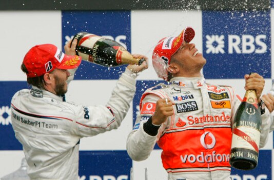 FILE - In this Sunday, June 10, 2007 file photo, Sauber driver Nick Heidfeld, left, of Germany, and McLaren Mercedes driver Lewis Hamilton, right, of Britain, celebrate after Hamilton won the Canadian Grand Prix Formula One race at the Circuit Gilles Villeneuve in Montreal, Canada. British driver Lewis Hamilton made Formula One history on Sunday, Oct. 25, 2020 winning the Portuguese Grand Prix for a 92nd win to move one ahead of German great Michael Schumacher. (AP Photo/Darron Cummings, file)