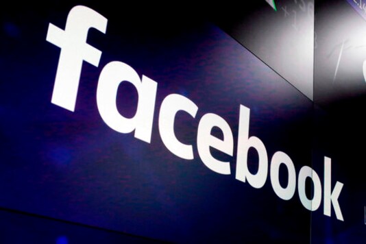 FILE - In this March 29, 2018, file photo, the logo for Facebook appears on screens at the Nasdaq MarketSite in New York's Times Square.  Academics, journalists and First Amendment lawyers are rallying behind New York University researchers in a showdown with Facebook over its demand that they halt the collection of data on political ads-targeting on the worlds dominant social media platform.  (AP Photo/Richard Drew, File)
