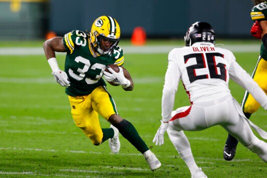Green Bay Packers' Aaron Jones (33) runs against Atlanta Falcons' Isaiah Oliver (26) during the first half of an NFL football game, Monday, Oct. 5, 2020, in Green Bay, Wis. (AP Photo/Tom Lynn) Green Bay Packers' Aaron Jones (33) runs against Atlanta Falcons' Isaiah Oliver (26) during the first half of an NFL football game, Monday, Oct. 5, 2020, in Green Bay, Wis. (AP Photo/Tom Lynn)
