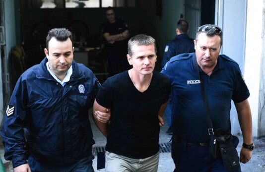 FILE - In this Oct.4, 2017 file photo, police officers escort Alexander Vinnik, center as they leave a courthouse at the northern Greek city of Thessaloniki. The Russian bitcoin fraud suspect Alexander Vinnik goes on trial on Monday in Paris for allegedly having used ransomware in a fraud involving 200 victims and estimated to a global amount of 135 million euros. Alexander Vinnik, who is also wanted in the United States and in Russia, is facing up to ten years in prison in a four-day trial in France over charges of extorsion, money laundering and criminal association. (AP Photo/Giannis Papanikos, File) FILE - In this Oct.4, 2017 file photo, police officers escort Alexander Vinnik, center as they leave a courthouse at the northern Greek city of Thessaloniki. The Russian bitcoin fraud suspect Alexander Vinnik goes on trial on Monday in Paris for allegedly having used ransomware in a fraud involving 200 victims and estimated to a global amount of 135 million euros. Alexander Vinnik, who is also wanted in the United States and in Russia, is facing up to ten years in prison in a four-day trial in France over charges of extorsion, money laundering and criminal association. (AP Photo/Giannis Papanikos, File)
