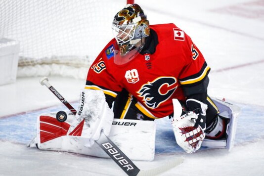 FILE - In this Jan. 28, 2020, file photo, Calgary Flames goalie Cam Talbot deflects a shot during the second period of an NHL hockey game against the St. Louis Blues in Calgary, Alberta. The former Flames goalie signed an $11 million, three-year deal with the Minnesota Wild.  (Jeff McIntosh/The Canadian Press via AP, File)