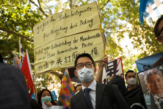 File---File picture taken Sept.1, 2020 shows Hong Kong activist Nathan Law, center, taking part in a protest during the visit of Chinese Foreign Minister Wang Yi in Berlin, Germany,   (AP Photo/Markus Schreiber,file)