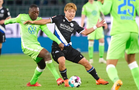 Wolfsburg's Jerome Roussillon, left and Bielefeld's Ritsu Doan fight for the ball during a German Bundesliga soccer match between VfL Wolfsburg and Arminia Bielefeld in Wolfsburg, Germany, Sunday, Oct. 25, 2020. (Peter Steffen/dpa via AP)