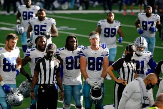 Dallas Cowboys players, Blake Bell (80), DeMarcus Lawrence (90), Dalton Schultz (86), Ezekiel Elliott (21) and others look on as quarterback Dak Prescott, not shown, receives medical attention after suffering a lower right leg injury running the ball against the New York Giants in the second half of an NFL football game in Arlington, Texas, Sunday, Oct. 11, 2020. (AP Photo/Michael Ainsworth) Dallas Cowboys players, Blake Bell (80), DeMarcus Lawrence (90), Dalton Schultz (86), Ezekiel Elliott (21) and others look on as quarterback Dak Prescott, not shown, receives medical attention after suffering a lower right leg injury running the ball against the New York Giants in the second half of an NFL football game in Arlington, Texas, Sunday, Oct. 11, 2020. (AP Photo/Michael Ainsworth)
