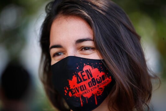 An anti-fascist protester, waring a mask to help prevent the spread of the coronavirus, gathers outside the court in Athens where the the sentencing announcement of the Golden Dawn trial, was schedule to be held, Wednesday, Oct. 14, 2020. The lengthy sentencing procedure is the final chapter in a more than five-year politically charged trial that encompassed four cases and involved 68 defendants, more than 200 witnesses and over 60 lawyers. The mask reads in Greek: 'Theyare not innocent, Nazis to prison'.(AP Photo/Thanassis Stavrakis) An anti-fascist protester, waring a mask to help prevent the spread of the coronavirus, gathers outside the court in Athens where the the sentencing announcement of the Golden Dawn trial, was schedule to be held, Wednesday, Oct. 14, 2020. The lengthy sentencing procedure is the final chapter in a more than five-year politically charged trial that encompassed four cases and involved 68 defendants, more than 200 witnesses and over 60 lawyers. The mask reads in Greek: 'Theyare not innocent, Nazis to prison'.(AP Photo/Thanassis Stavrakis)